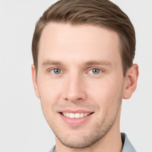 Joyful white young-adult male with short  brown hair and grey eyes