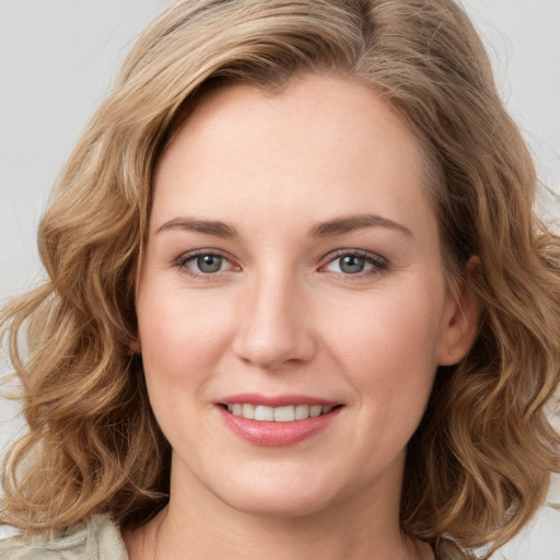 Joyful white young-adult female with long  brown hair and blue eyes