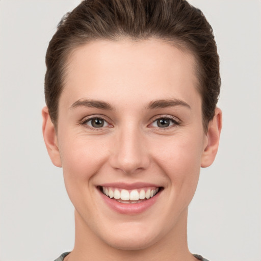 Joyful white young-adult female with short  brown hair and grey eyes