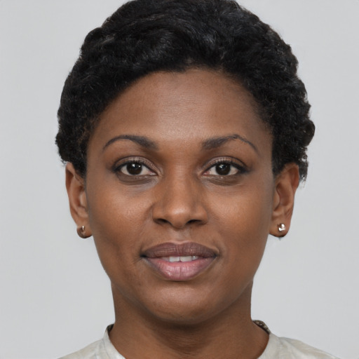 Joyful black young-adult female with short  black hair and brown eyes