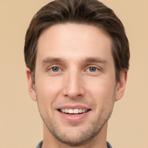 Joyful white young-adult male with short  brown hair and grey eyes