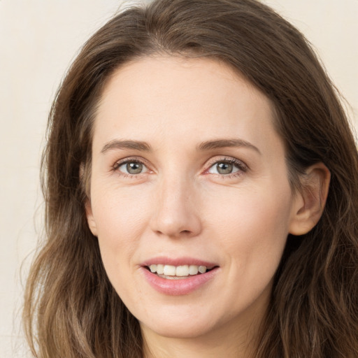 Joyful white young-adult female with long  brown hair and grey eyes