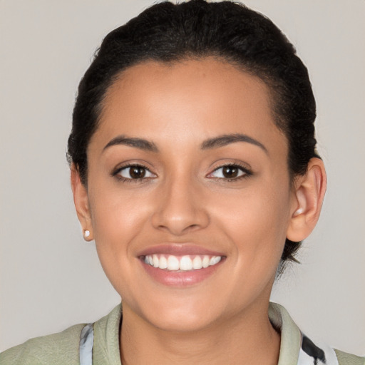 Joyful latino young-adult female with short  brown hair and brown eyes