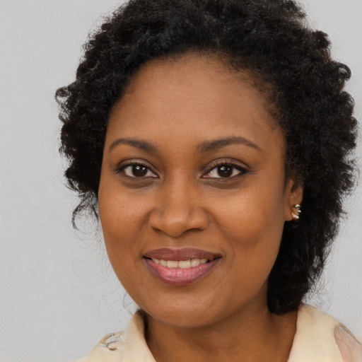 Joyful black adult female with long  brown hair and brown eyes