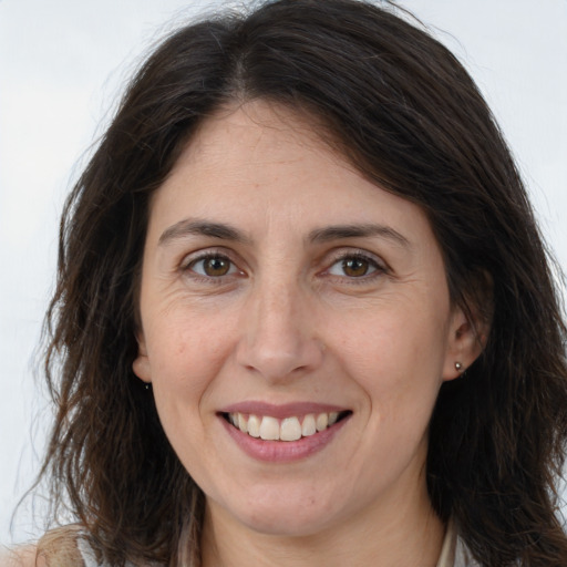 Joyful white adult female with long  brown hair and brown eyes