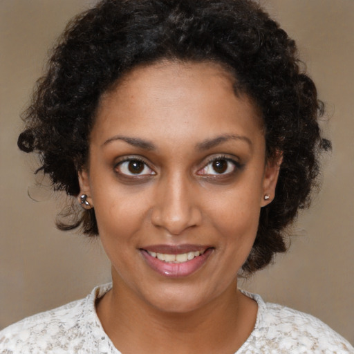 Joyful black young-adult female with medium  brown hair and brown eyes