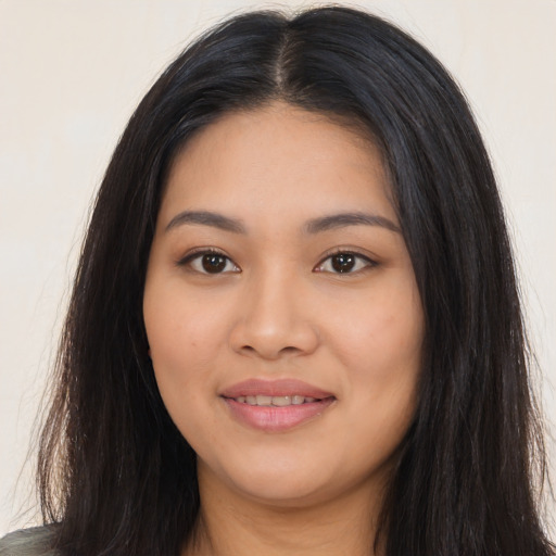 Joyful latino young-adult female with long  black hair and brown eyes