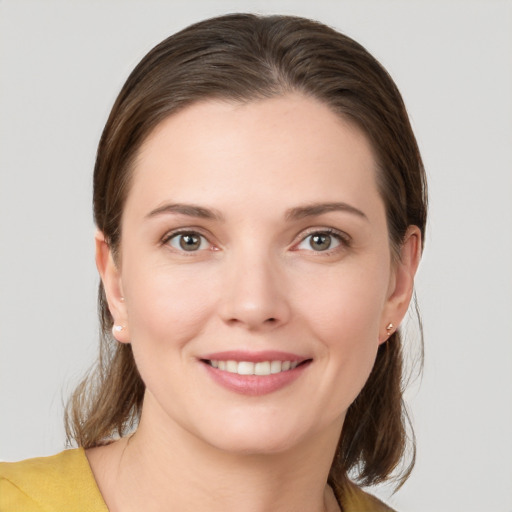 Joyful white young-adult female with medium  brown hair and grey eyes