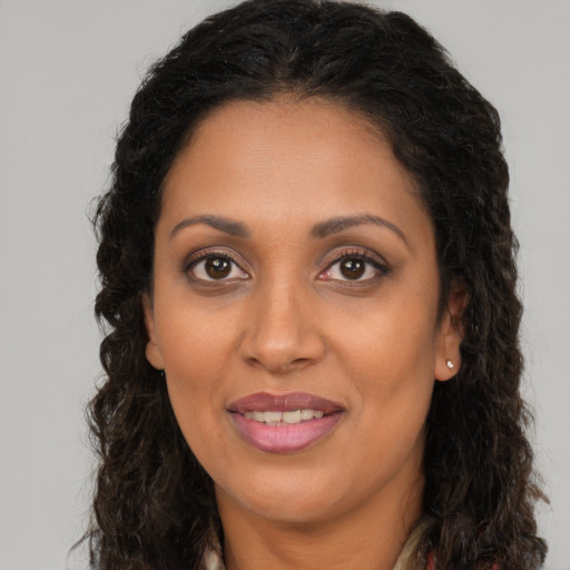 Joyful latino adult female with long  brown hair and brown eyes