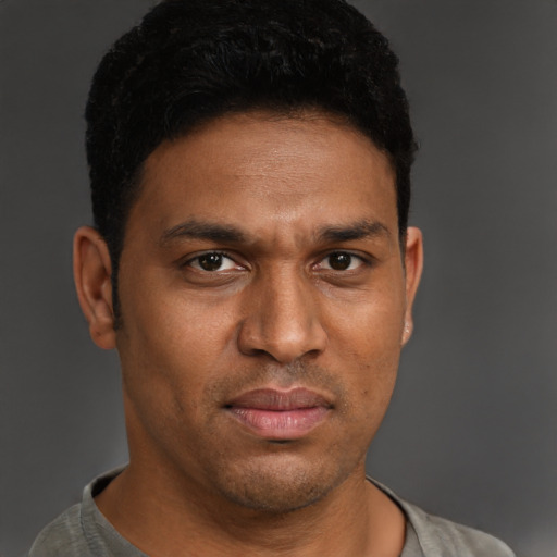 Joyful black young-adult male with short  brown hair and brown eyes