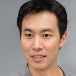 Joyful asian young-adult male with short  black hair and brown eyes