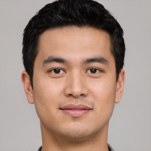 Joyful asian young-adult male with short  black hair and brown eyes
