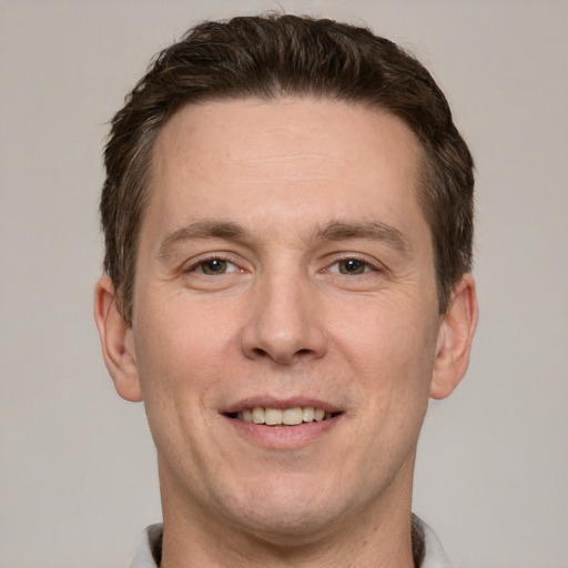 Joyful white adult male with short  brown hair and grey eyes