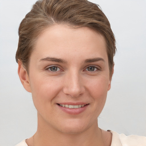 Joyful white young-adult female with short  brown hair and grey eyes