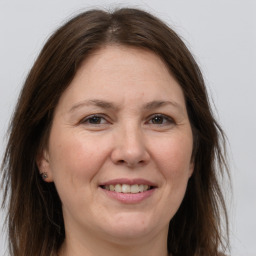 Joyful white adult female with long  brown hair and brown eyes