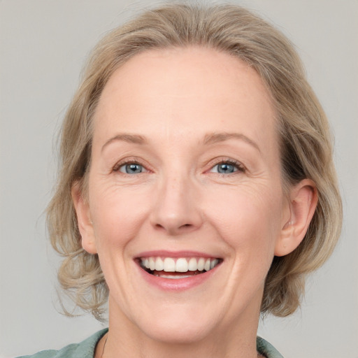 Joyful white adult female with medium  brown hair and blue eyes