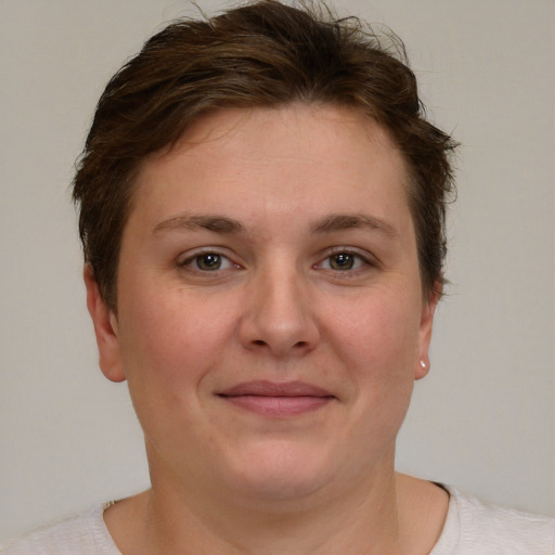 Joyful white young-adult female with short  brown hair and grey eyes