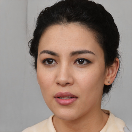 Joyful latino young-adult female with short  black hair and brown eyes