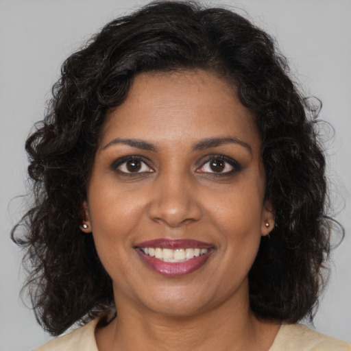 Joyful black young-adult female with long  brown hair and brown eyes