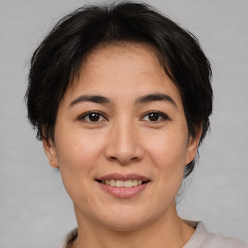 Joyful asian adult female with short  brown hair and brown eyes