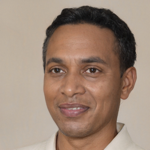 Joyful black adult male with short  black hair and brown eyes
