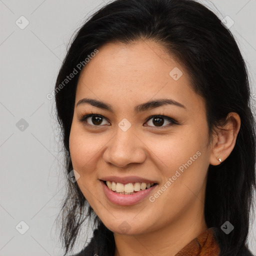 Joyful latino young-adult female with long  brown hair and brown eyes