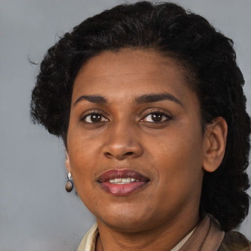 Joyful black adult female with short  brown hair and brown eyes