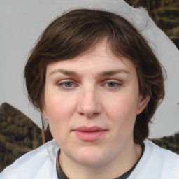 Joyful white young-adult female with medium  brown hair and blue eyes