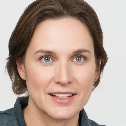 Joyful white adult female with medium  brown hair and grey eyes