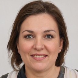 Joyful white adult female with medium  brown hair and brown eyes