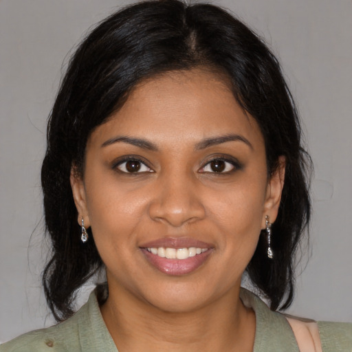 Joyful black young-adult female with medium  brown hair and brown eyes