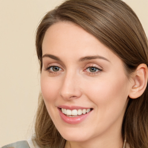 Joyful white young-adult female with long  brown hair and green eyes