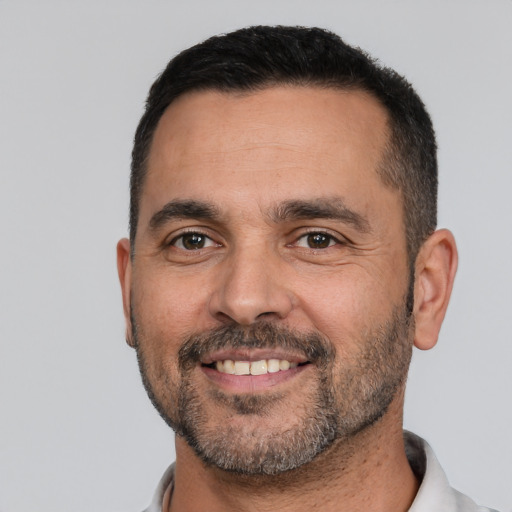 Joyful white adult male with short  black hair and brown eyes