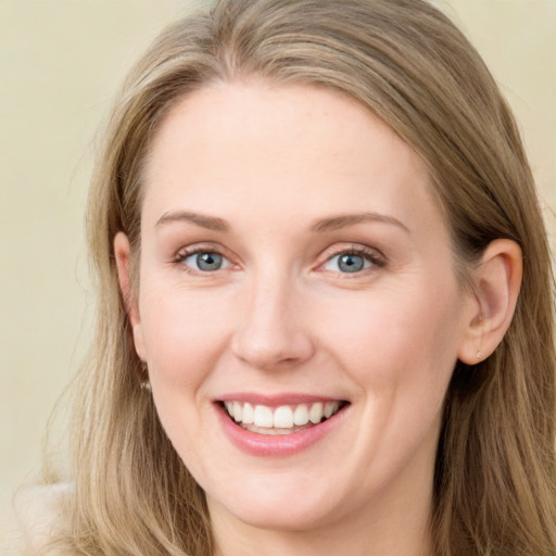 Joyful white young-adult female with long  brown hair and blue eyes