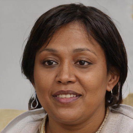 Joyful latino adult female with medium  brown hair and brown eyes