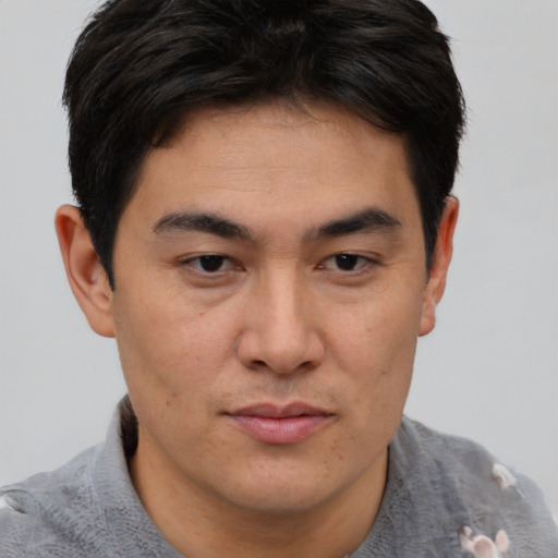 Joyful asian young-adult male with short  brown hair and brown eyes