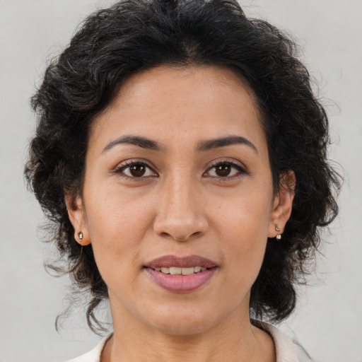 Joyful latino adult female with medium  brown hair and brown eyes