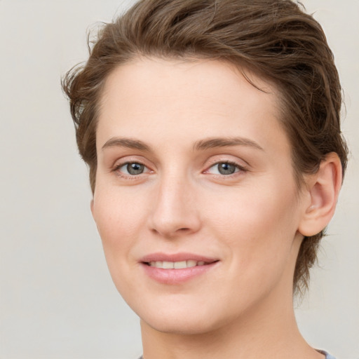 Joyful white young-adult female with medium  brown hair and green eyes