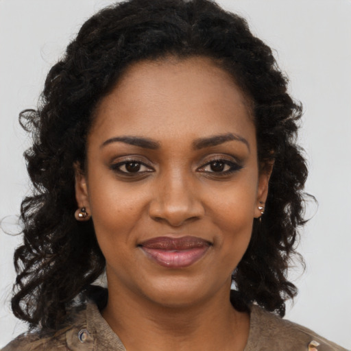 Joyful black young-adult female with long  black hair and brown eyes