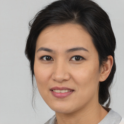 Joyful asian young-adult female with medium  brown hair and brown eyes