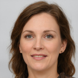 Joyful white adult female with long  brown hair and grey eyes