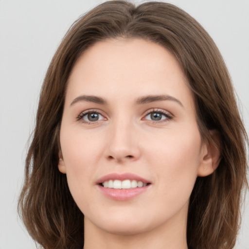 Joyful white young-adult female with long  brown hair and brown eyes