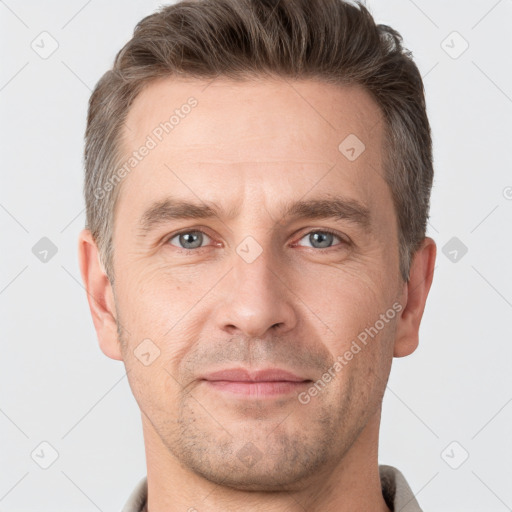 Joyful white adult male with short  brown hair and grey eyes