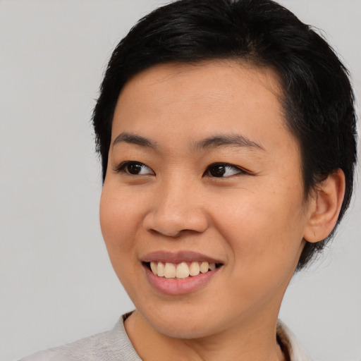 Joyful asian young-adult female with short  black hair and brown eyes