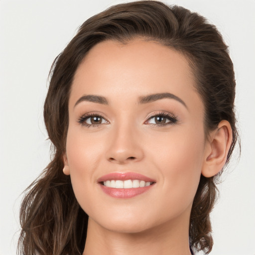 Joyful white young-adult female with long  brown hair and brown eyes