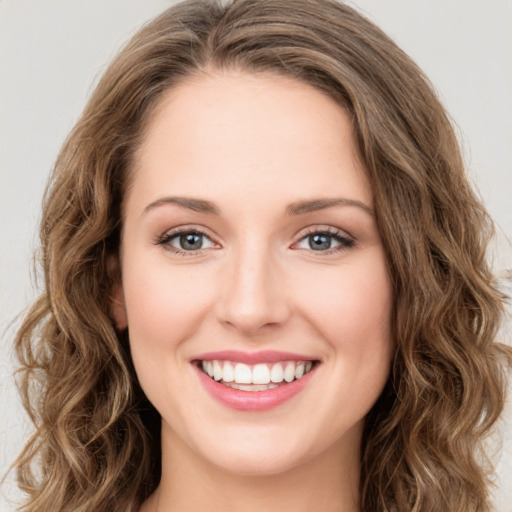 Joyful white young-adult female with long  brown hair and green eyes