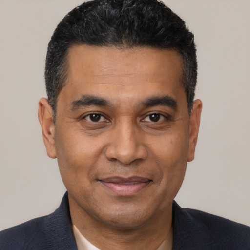 Joyful latino adult male with short  black hair and brown eyes
