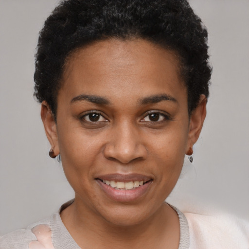 Joyful black young-adult female with short  black hair and brown eyes
