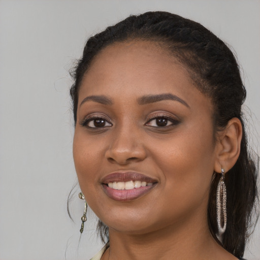 Joyful black young-adult female with long  black hair and brown eyes