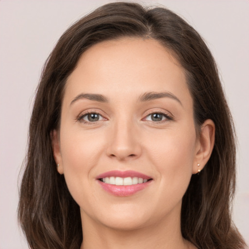 Joyful white young-adult female with long  brown hair and grey eyes